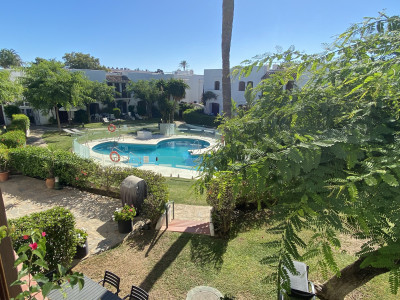 Estepona, Front-line beach townhouse in an excellent location between Estepona and Marbella with beautiful gardens and pool